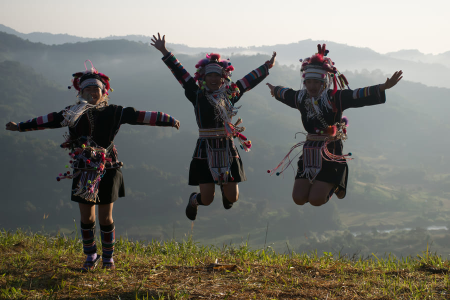 Personaas del pueblo de akha bailando y saltando